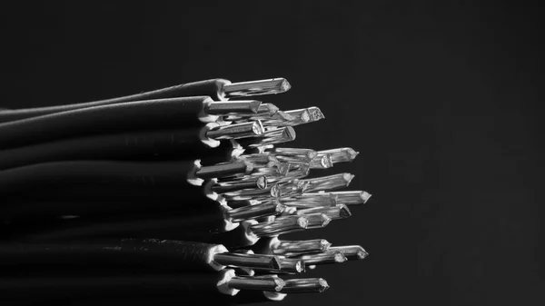 Bundles of cables with exposed metal conductors at the ends, black-and-white photograph
