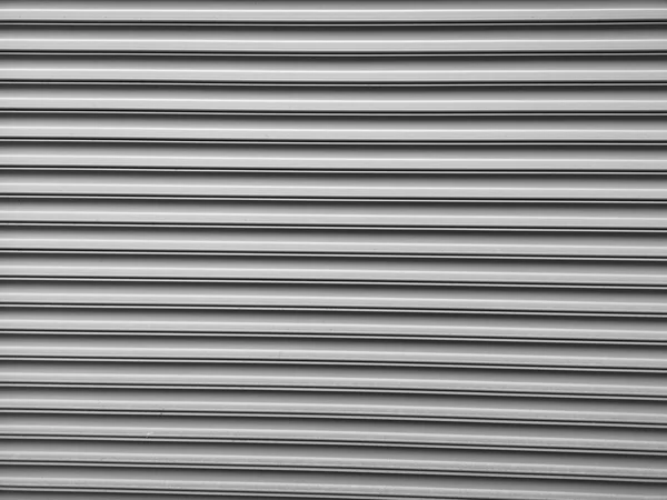 Slats of a closed metal roller shutter, close-up photograph in black and white