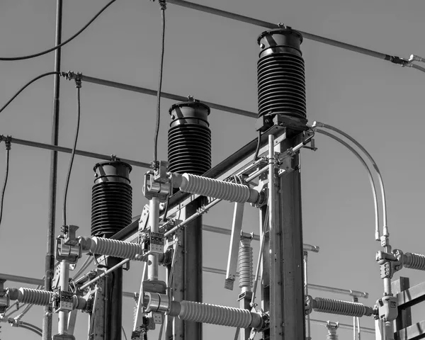 Equipment at a high-voltage electrical substation, insulators and busbars, black-and-white photograph