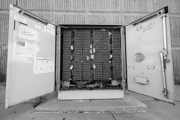 Armadio di permutazione telefonico aperto con centinaia di doppini in rame etichettati
